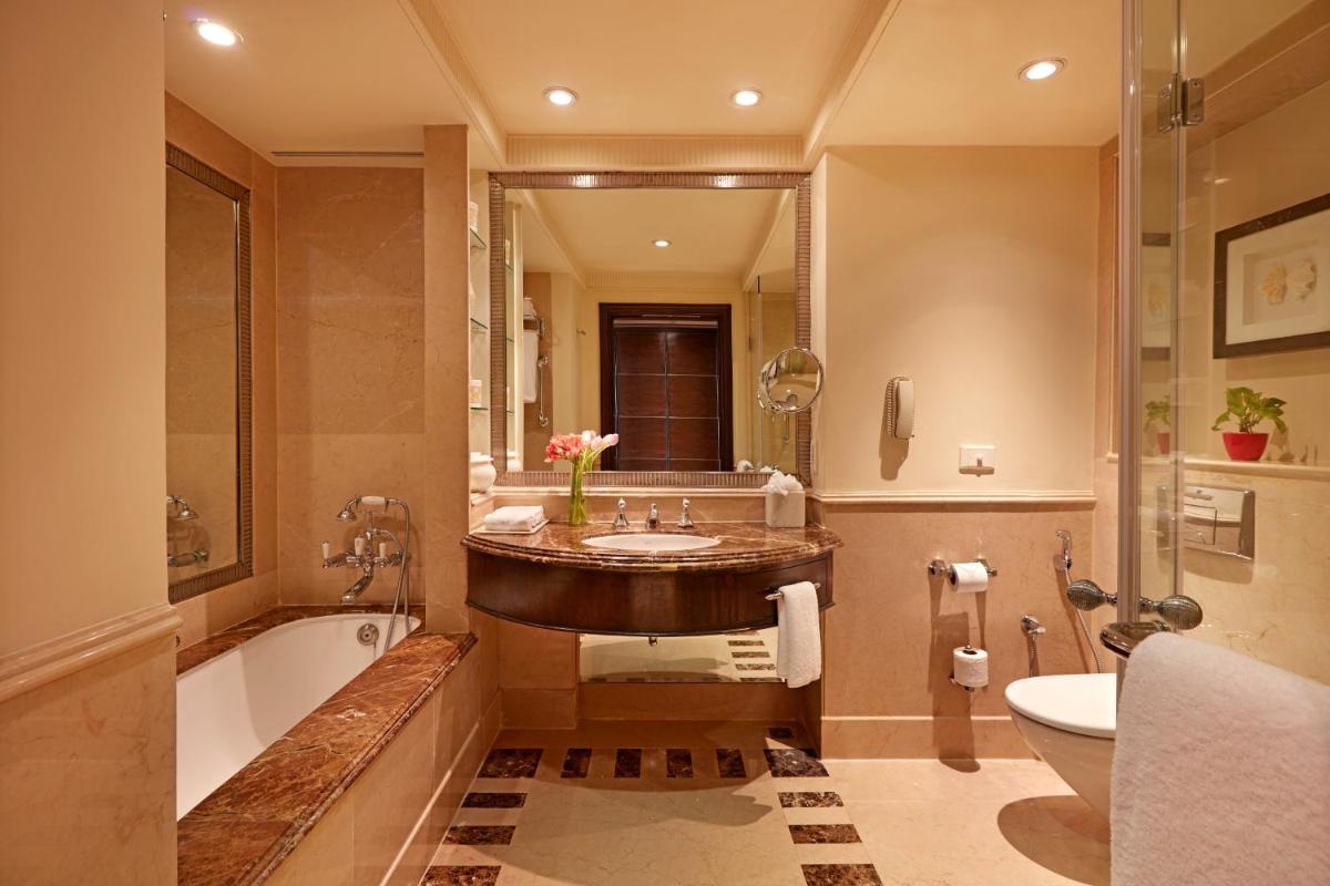 a bathroom with a tub and a sink and a bath tub at ITC Maratha, a Luxury Collection Hotel, Mumbai in Mumbai
