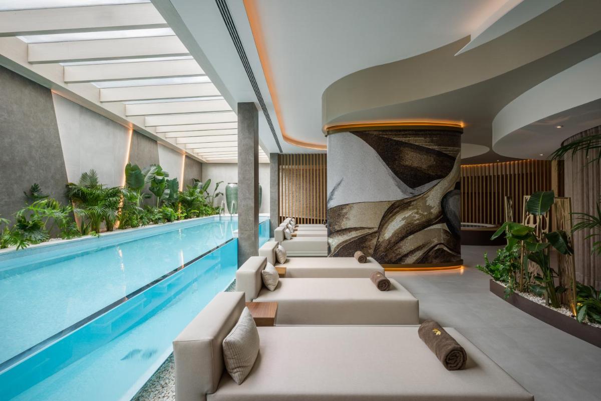 uma piscina com uma fileira de cadeiras ao lado da piscina em Hyatt Regency Lisbon em Lisboa