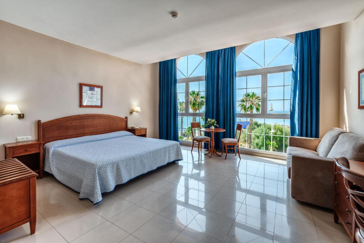 Un dormitorio con una cama, un sofá y una mesa. en Bahía Tropical, en Almuñécar 86 fotos más