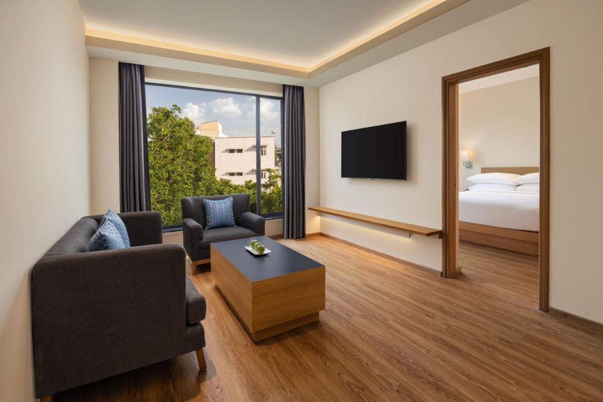 a living room with a couch and a bed and a mirror at Fairfield by Marriott Jaipur in Jaipur