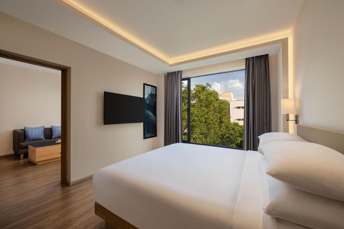 a bedroom with a large bed and a large window at Fairfield by Marriott Jaipur in Jaipur