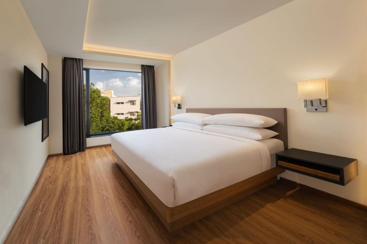 a bedroom with a large white bed and a window at Fairfield by Marriott Jaipur in Jaipur