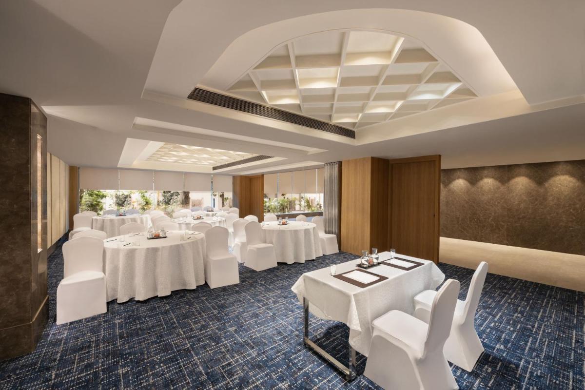 a dining room with white tables and white chairs at Fairfield by Marriott Jaipur in Jaipur