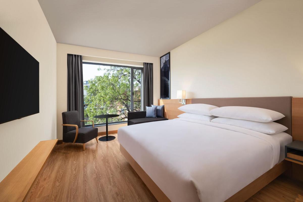 a hotel room with a large bed and a window at Fairfield by Marriott Jaipur in Jaipur