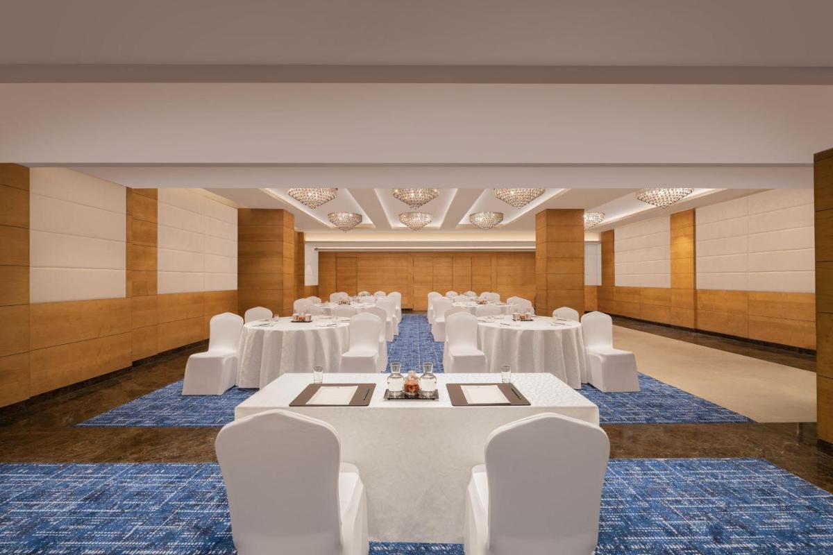 a banquet hall with white tables and white chairs at Fairfield by Marriott Jaipur in Jaipur
