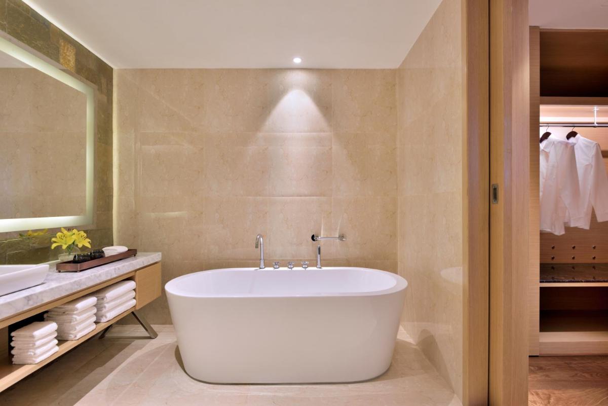 a bathroom with a large tub and a sink at Marriott Executive Apartments Hyderabad in Hyderabad