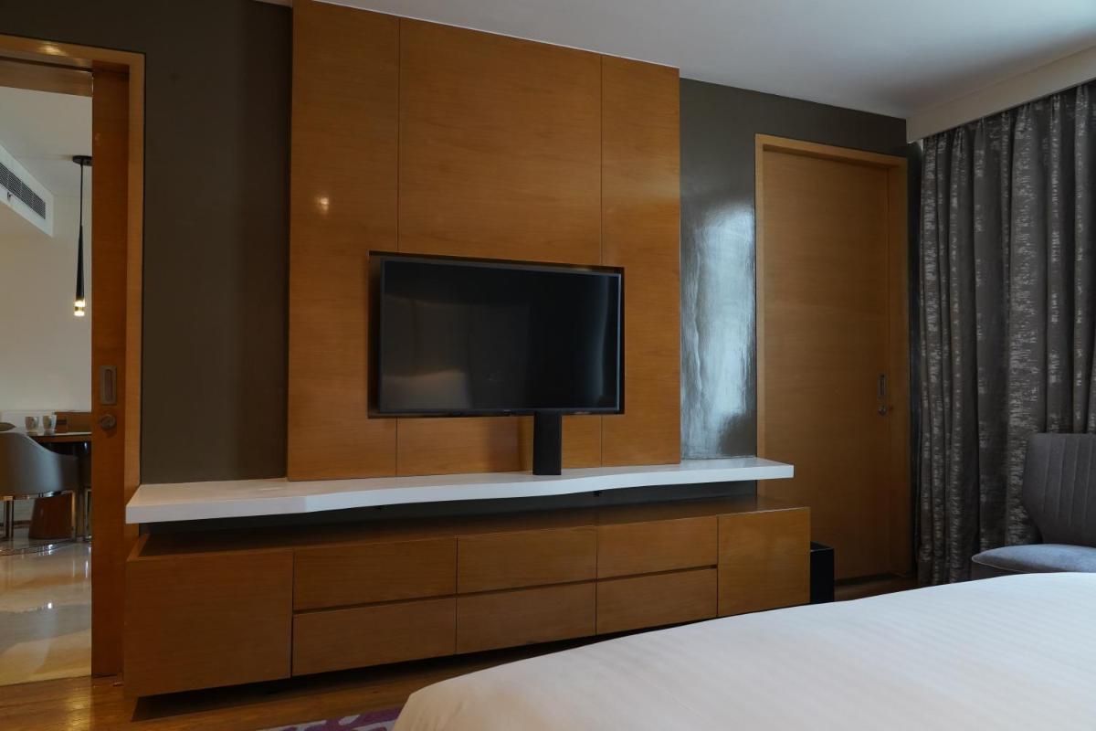 a bedroom with a flat screen tv on a wall at Marriott Executive Apartments Hyderabad in Hyderabad
