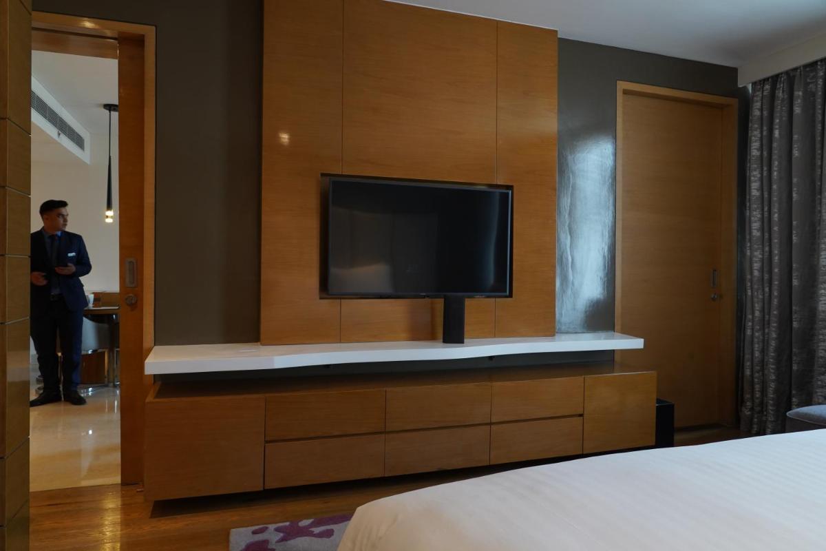 a tv on a wall in a hotel room at Marriott Executive Apartments Hyderabad in Hyderabad