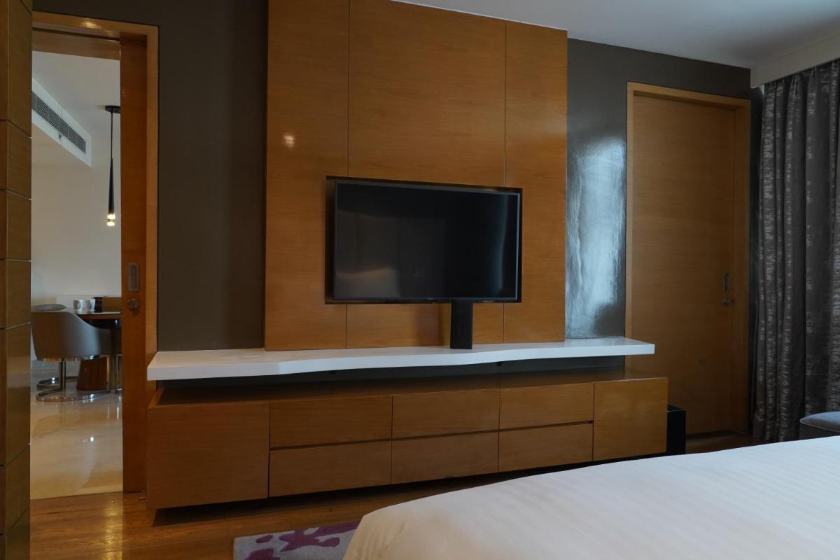 a bedroom with a tv on a wooden wall at Marriott Executive Apartments Hyderabad in Hyderabad