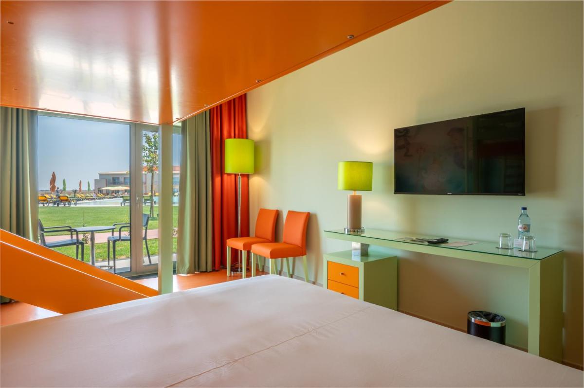 um quarto de hotel com uma cama, uma escrivaninha e uma janela em Vila Gale Nep Kids em Beja