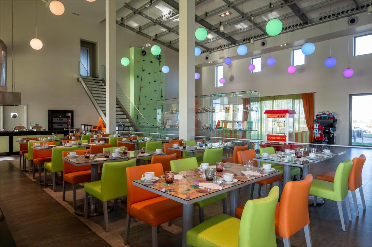 uma sala de jantar com mesas e cadeiras coloridas em Vila Gale Nep Kids em Beja