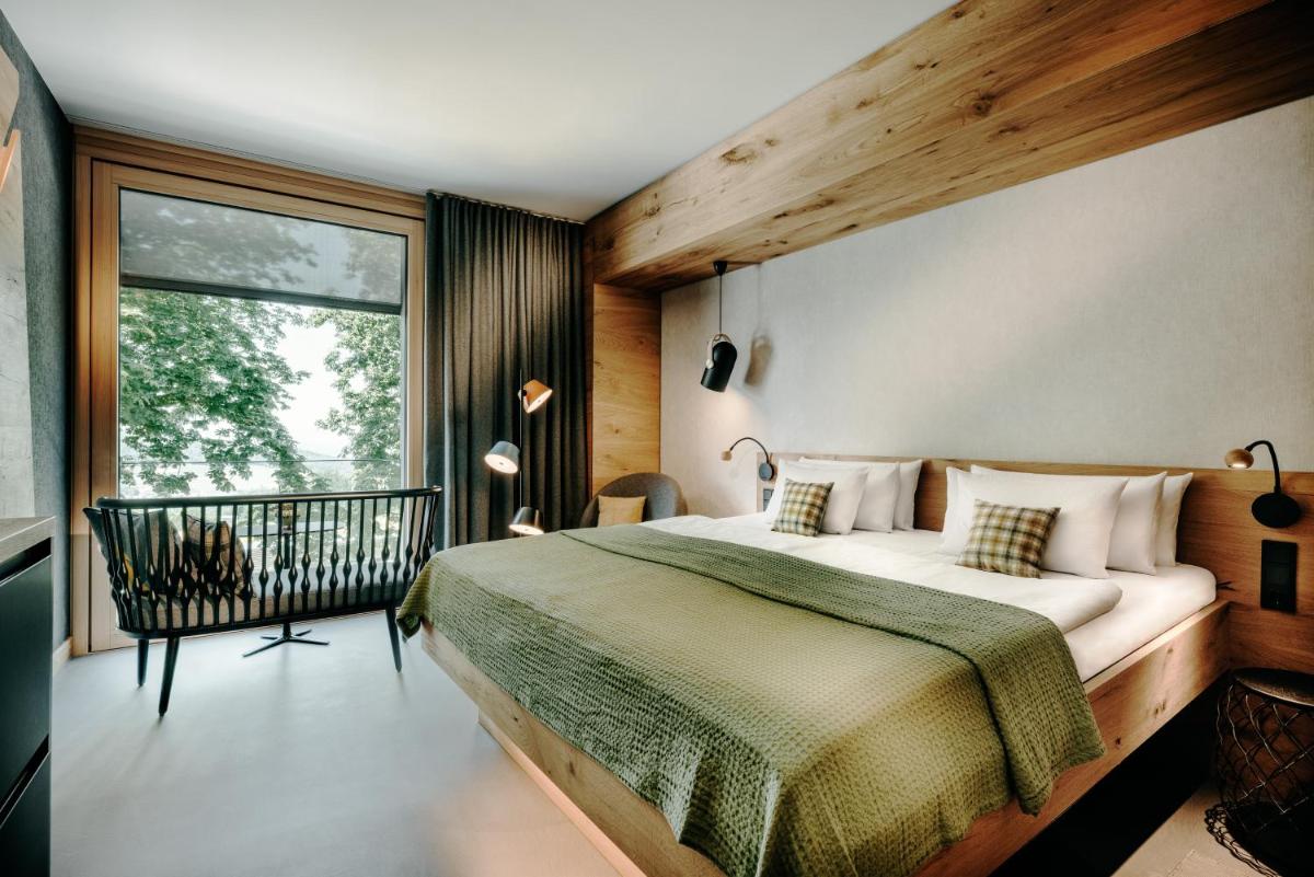 ein Schlafzimmer mit großem Bett und Fenster in der Unterkunft Luisenhöhe - Gesundheitsresort Schwarzwald in Horben