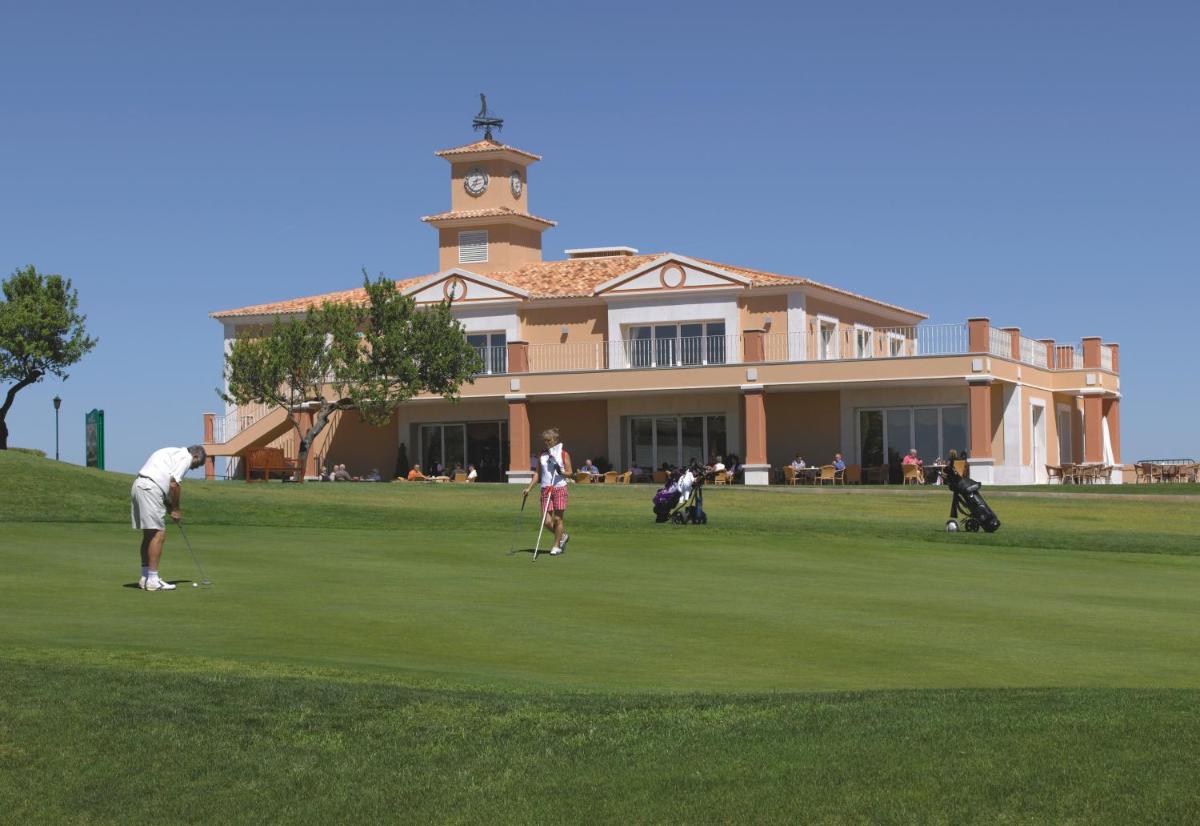 um grupo de pessoas a jogar golfe em frente a um edifício em Boavista Golf & Spa - Bela Colina Holidays em Lagos