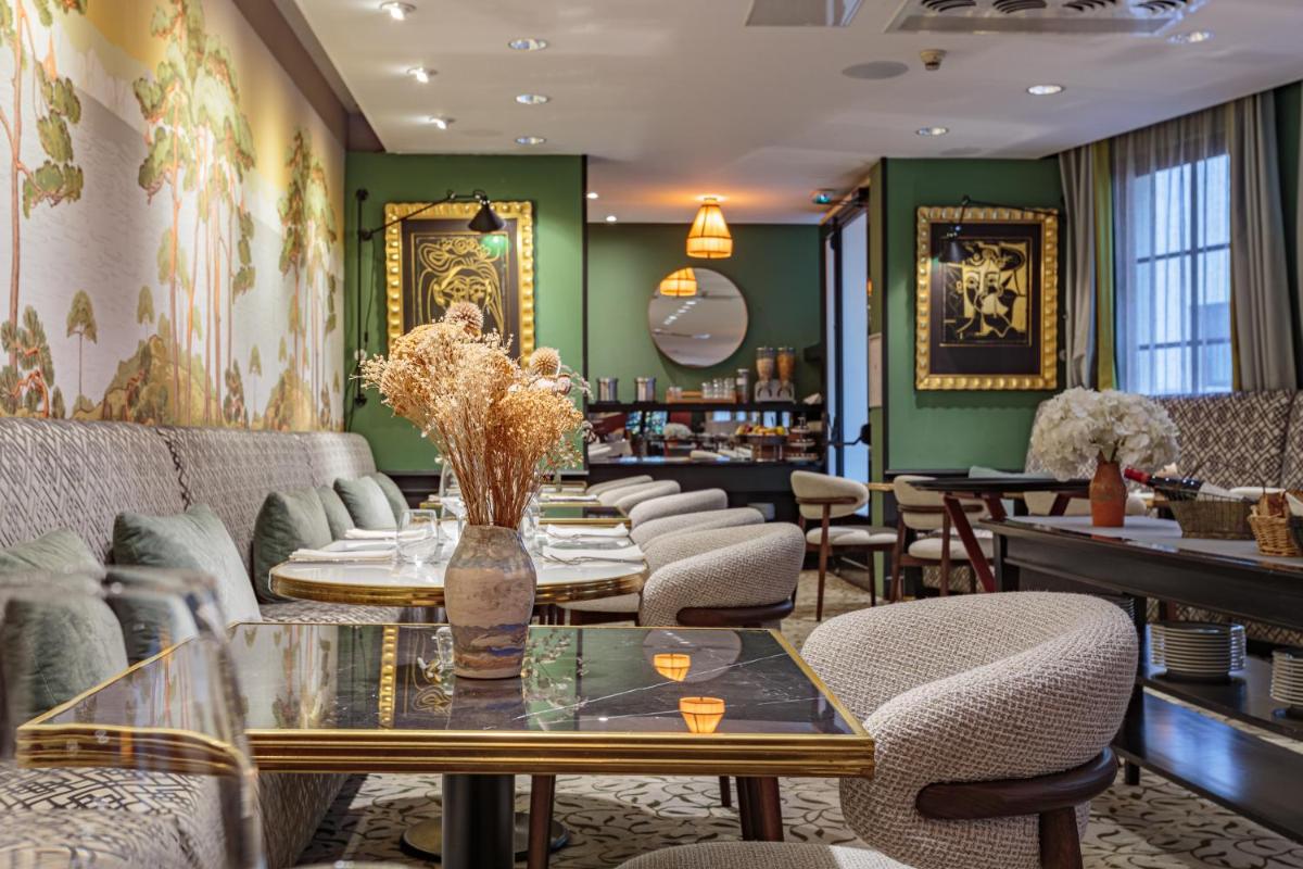 un restaurant avec des murs verts, des tables et des chaises dans l'établissement Grand Tonic Hotel & SPA NUXE, à Biarritz 54 autres photos