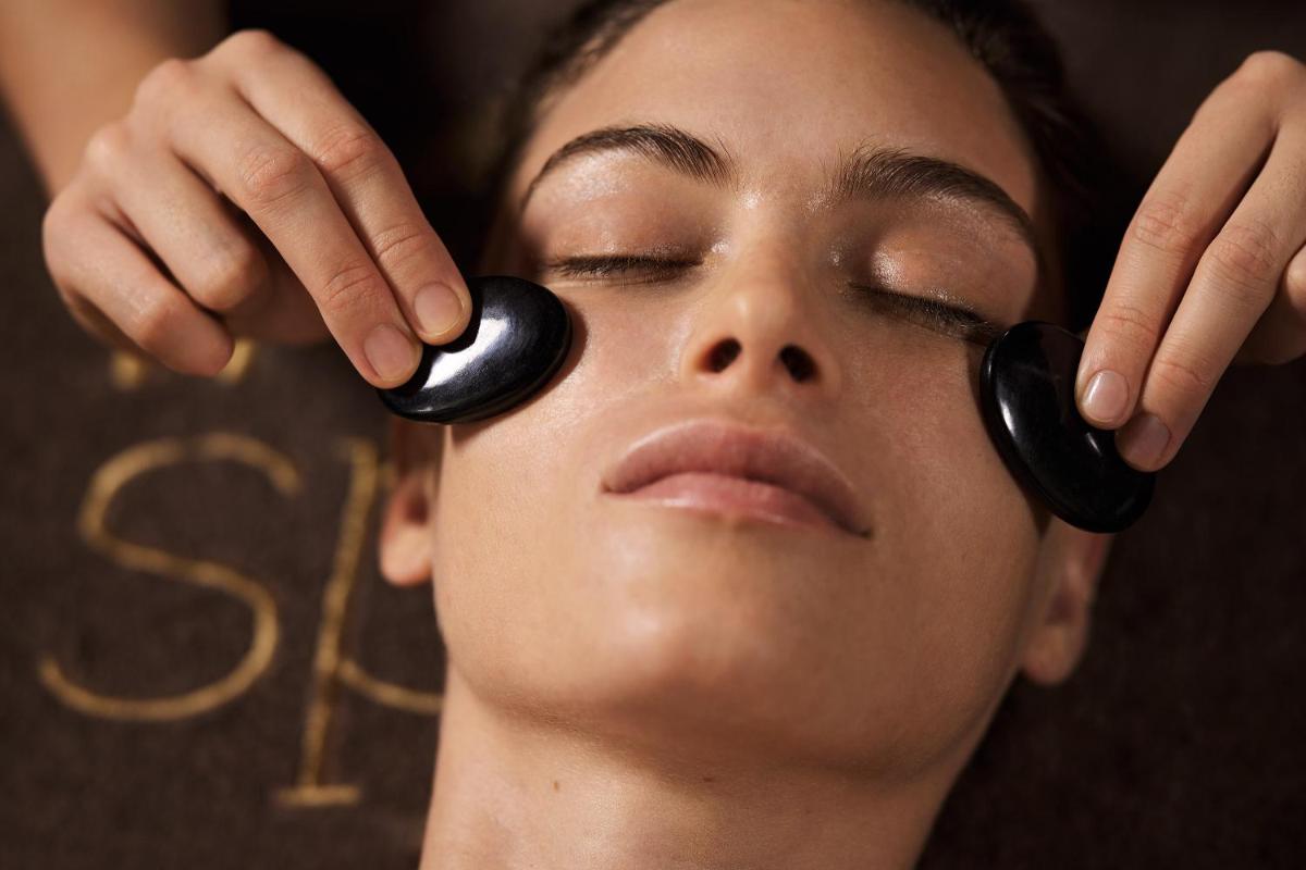 une femme avec des écouteurs noirs sur les yeux dans l'établissement Grand Tonic Hotel & SPA NUXE, à Biarritz