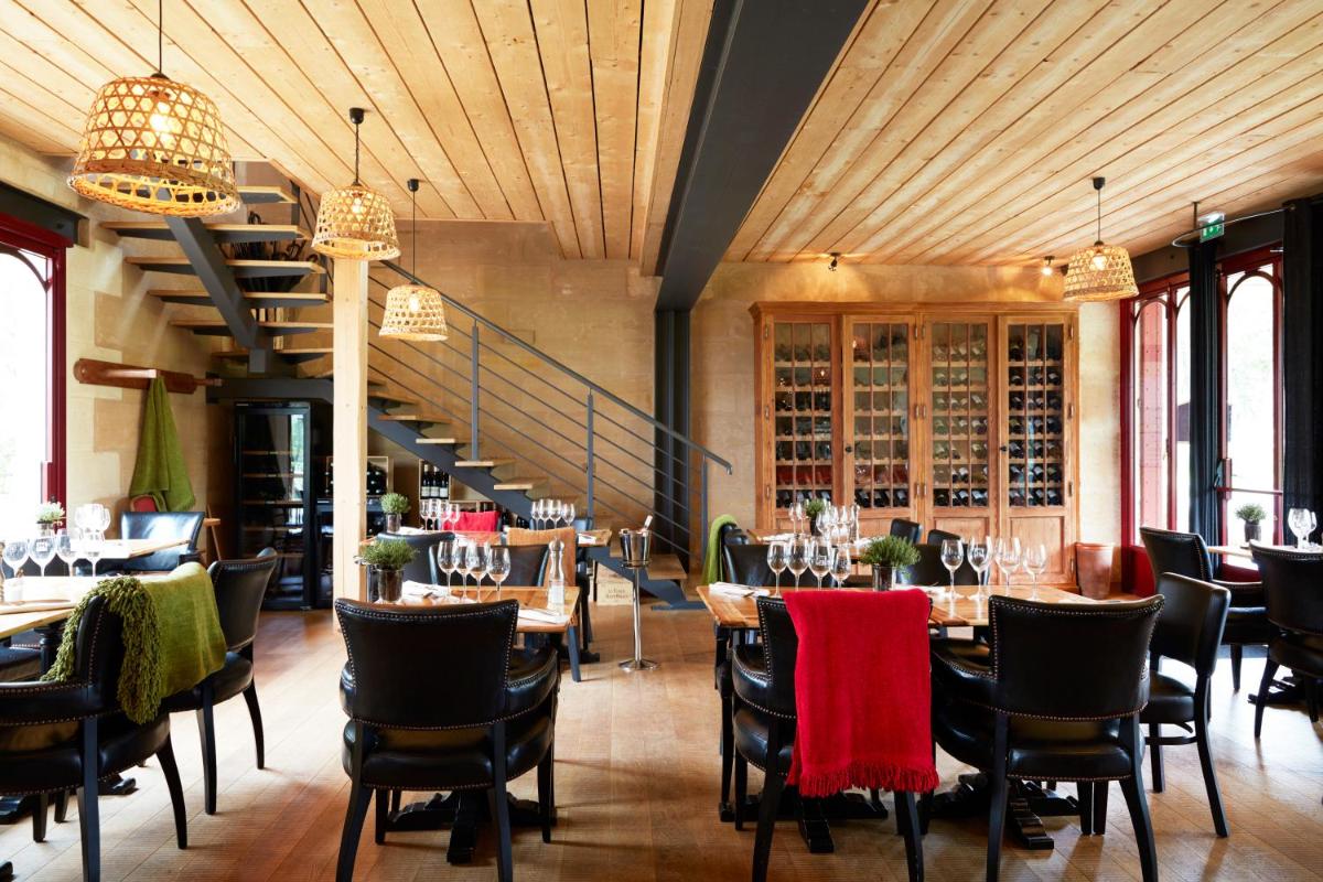 un restaurant avec des tables et des chaises et un escalier dans l'établissement Château Léognan, Domaine viticole - proche Bordeaux, à Léognan