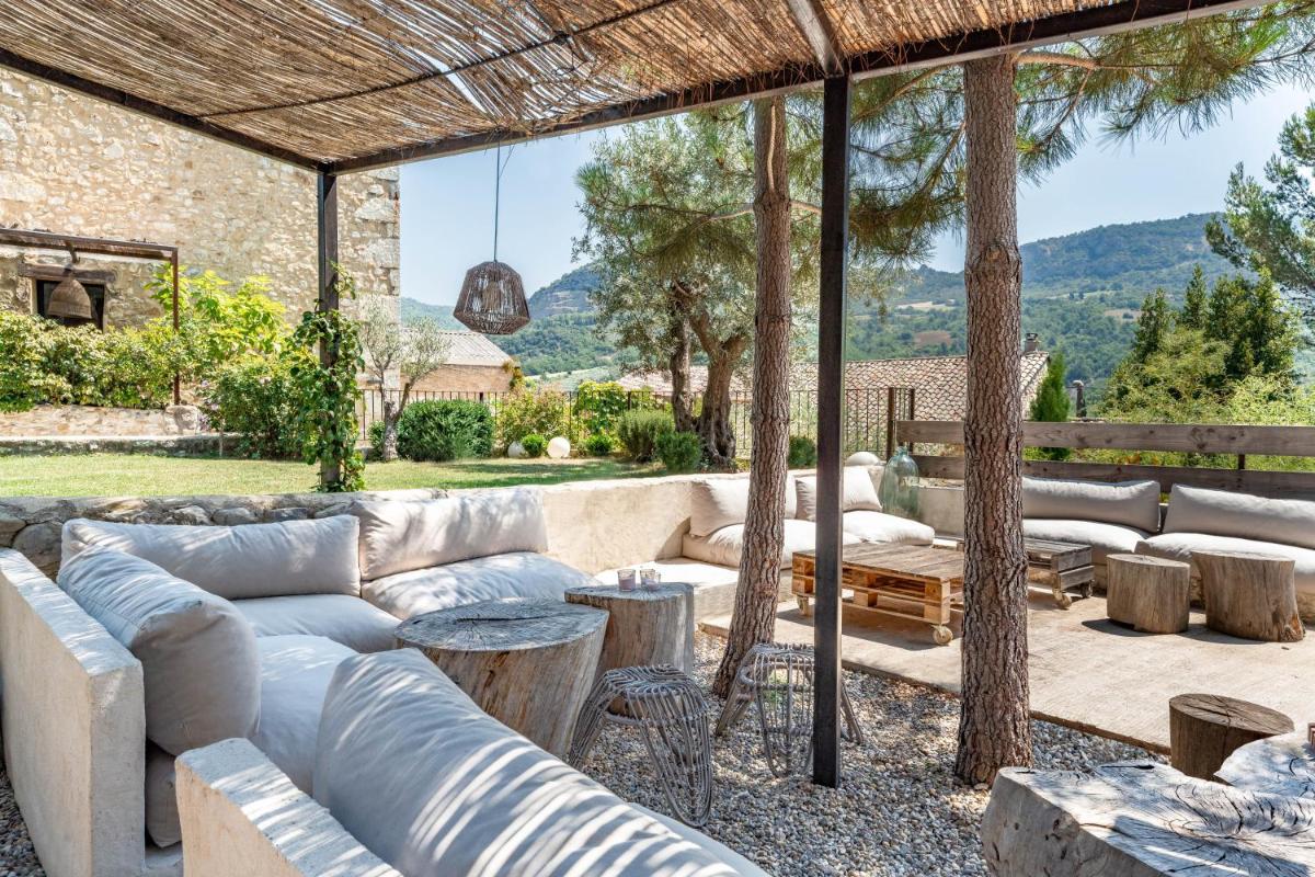 un patio avec des canapés, des tables et des arbres dans l'établissement DODO etc, à Nyons
