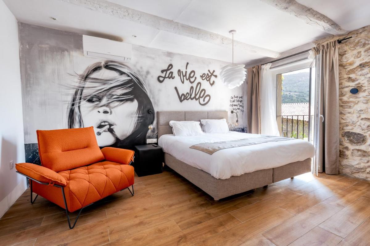 - une chambre avec un lit, une chaise et une fresque murale dans l'établissement DODO etc, à Nyons 51 autres photos