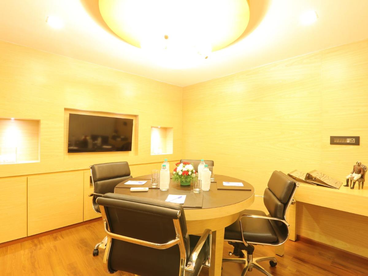 a conference room with a table and chairs at Deltin Suites in Candolim