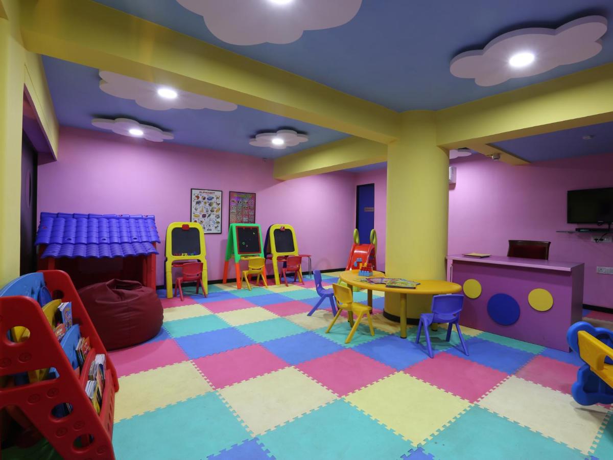 a room with a classroom with a table and chairs at Deltin Suites in Candolim