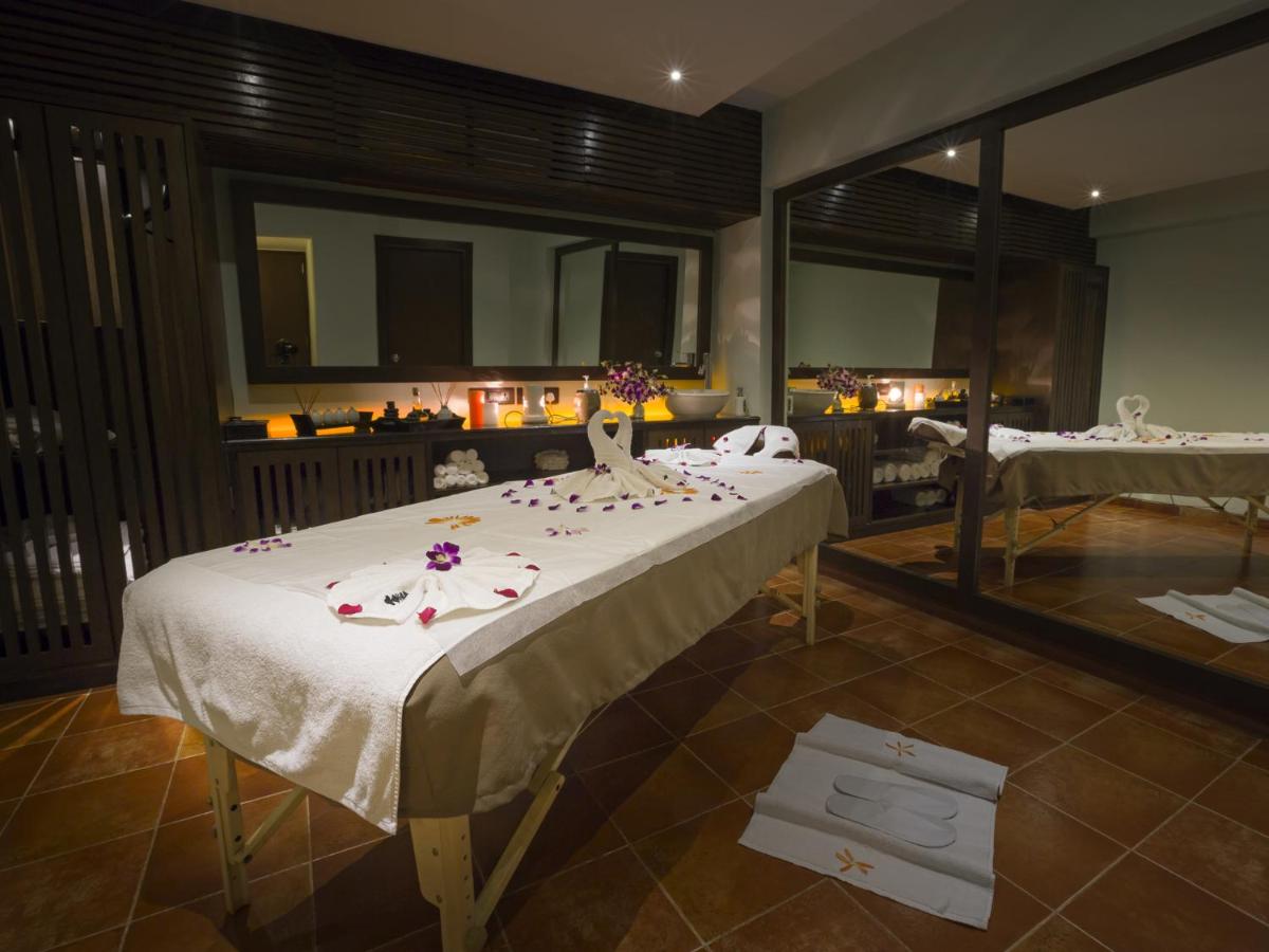a room with a large bed with flowers on it at Deltin Suites in Candolim