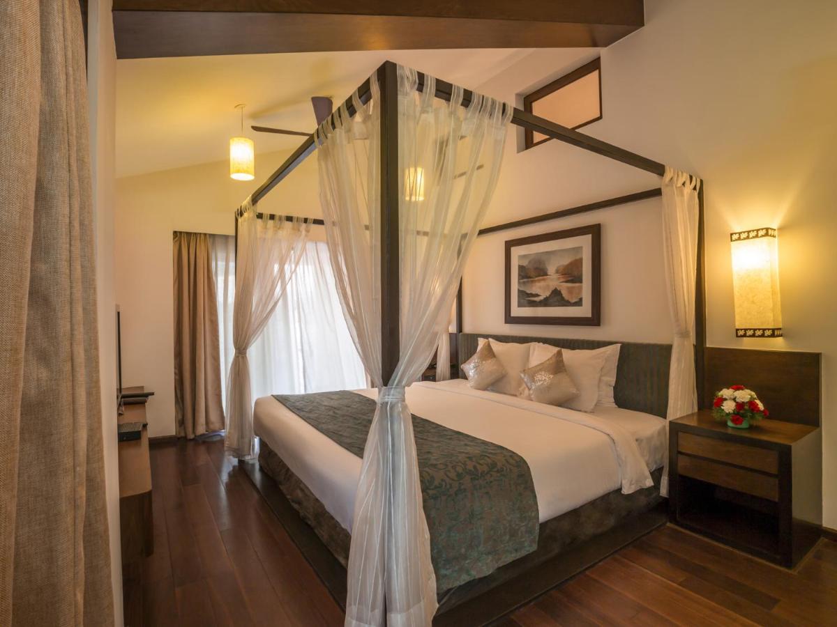 a bedroom with a bed with a canopy at Deltin Suites in Candolim