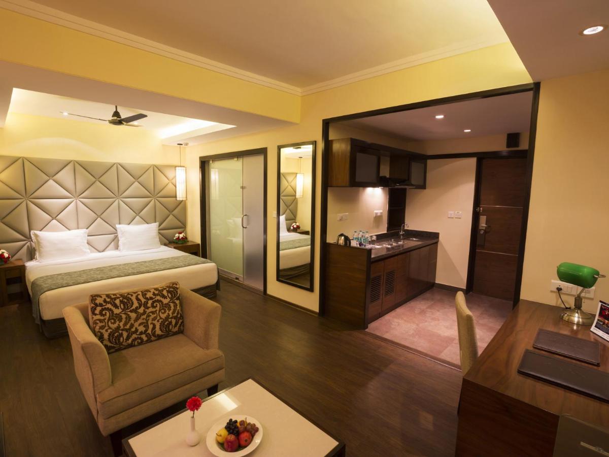 a hotel room with a bed and a living room at Deltin Suites in Candolim