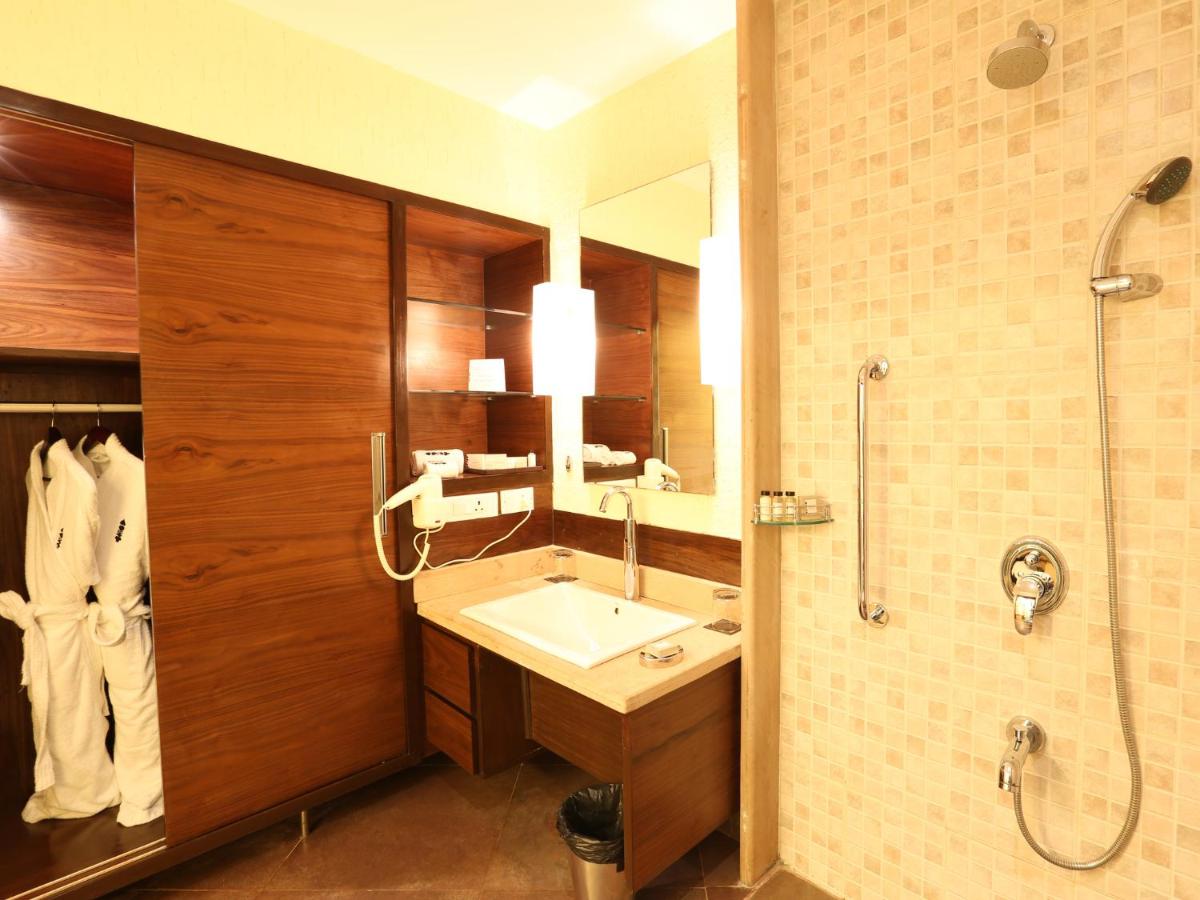 a bathroom with a sink and a shower at Deltin Suites in Candolim