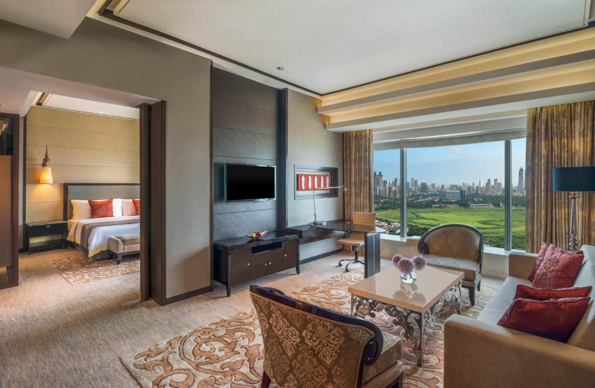 a hotel room with a bed and a living room at The St. Regis Mumbai in Mumbai
