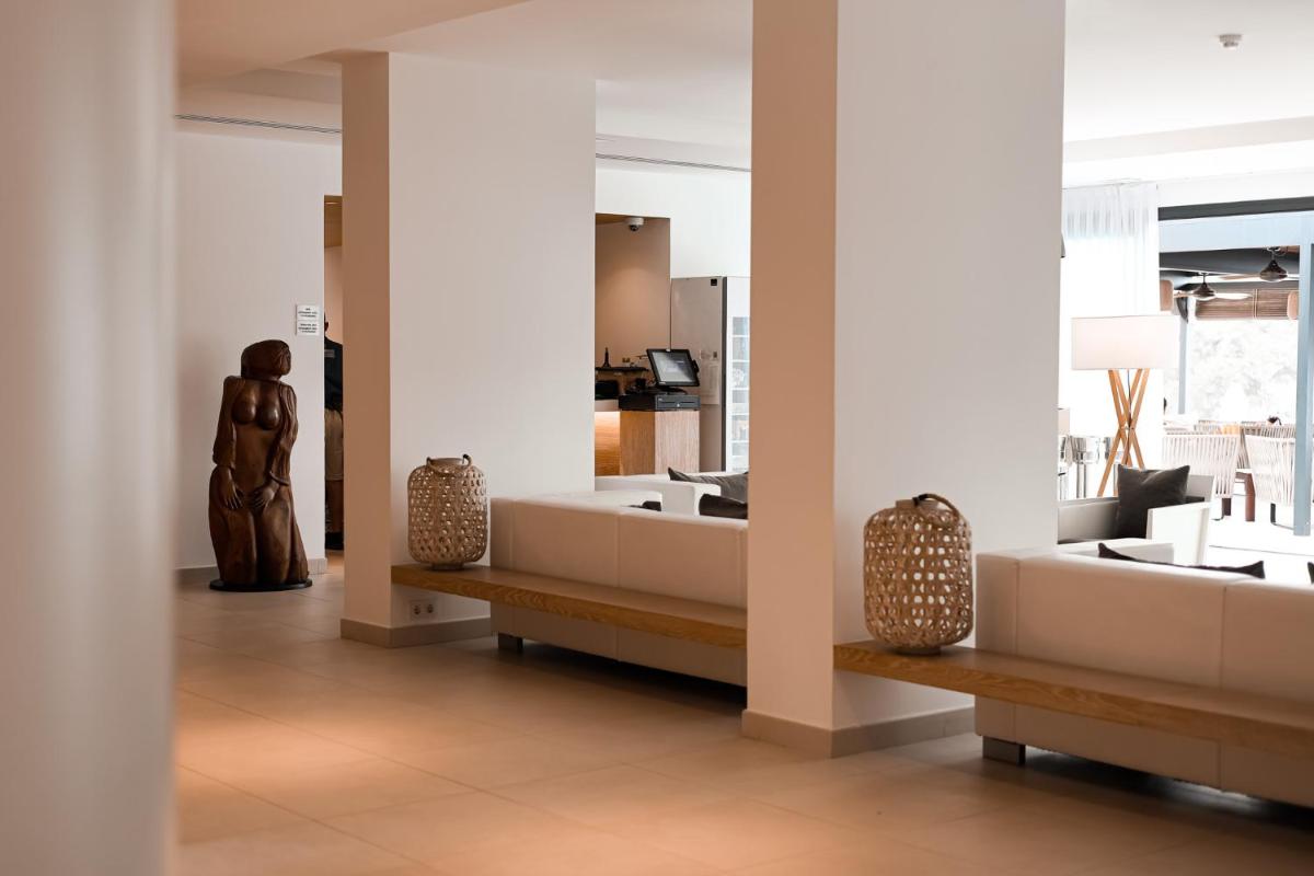Una habitación con una mujer de pie en una habitación. en Hotel Cala Saona & Spa, en Cala Saona