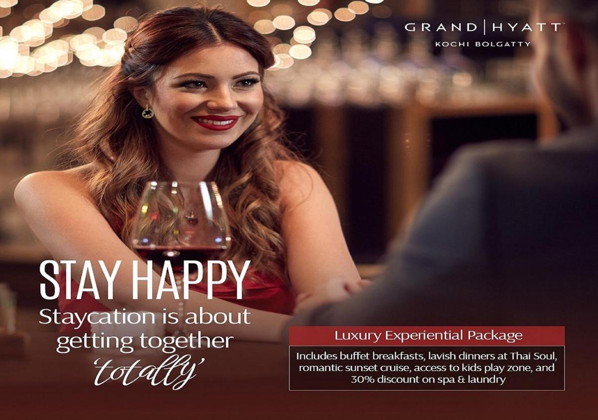 a woman is holding a glass of wine at Grand Hyatt Kochi Bolgatty in Cochin