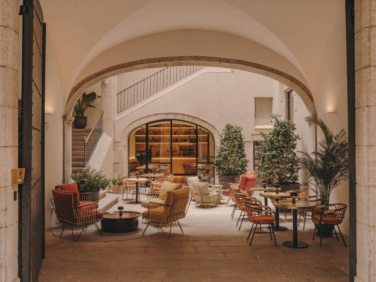 Un restaurante con mesas y sillas en un edificio. en Hotel Palau Fugit, en Girona