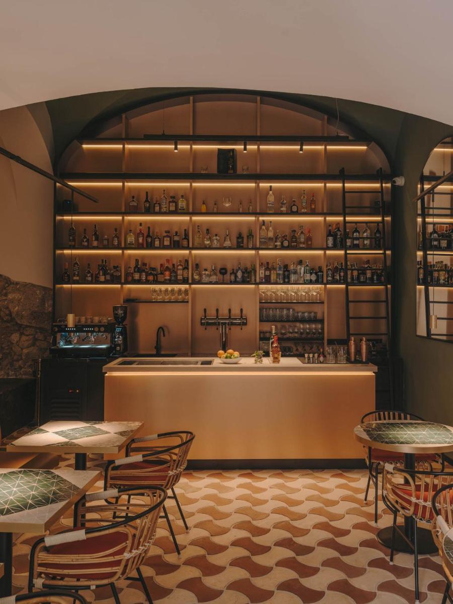 Un restaurante con mesas y sillas y un bar. en Hotel Palau Fugit, en Girona