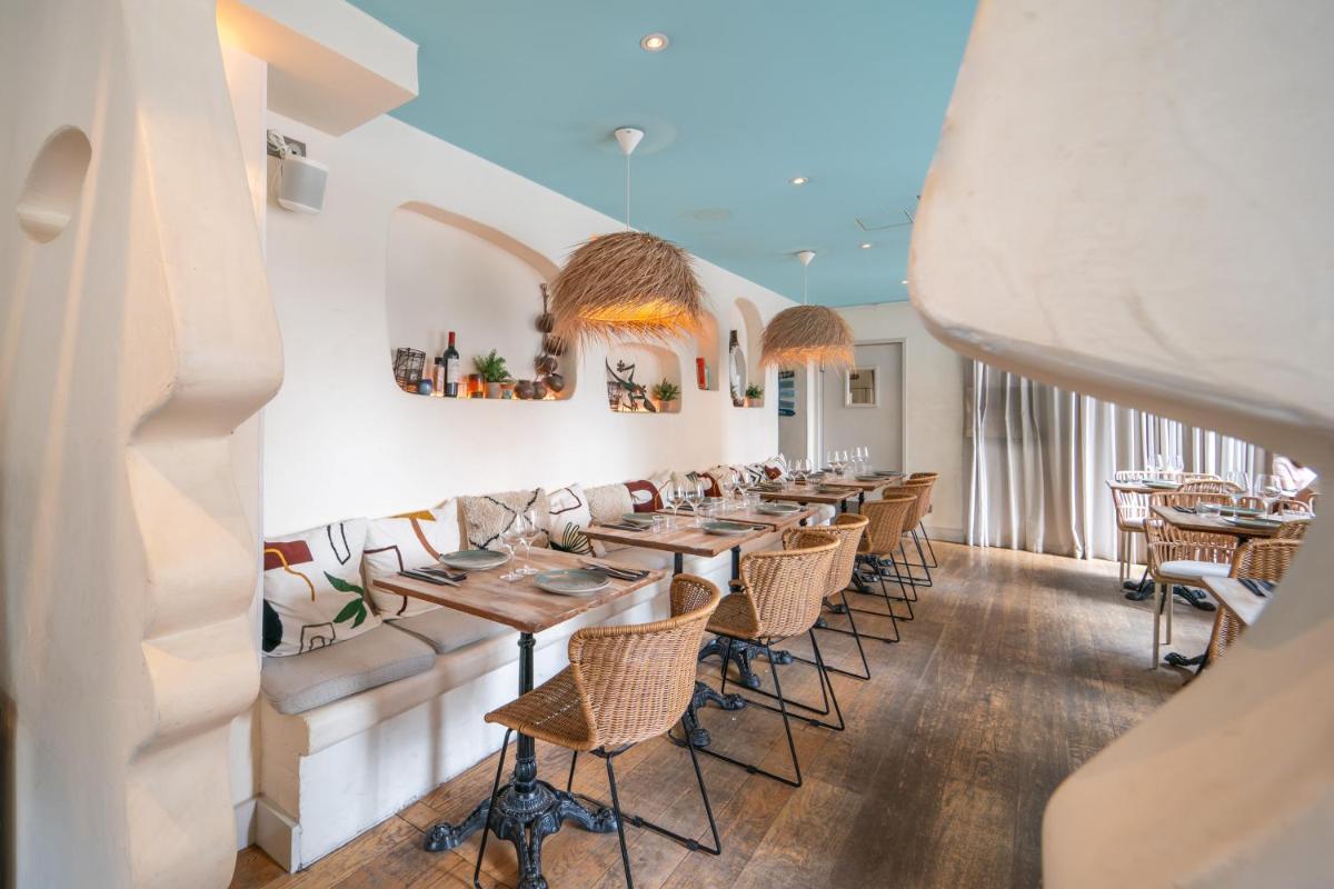 une rangée de tables et de chaises dans un restaurant dans l'établissement La Finca Hôtel & Spa, à Paris