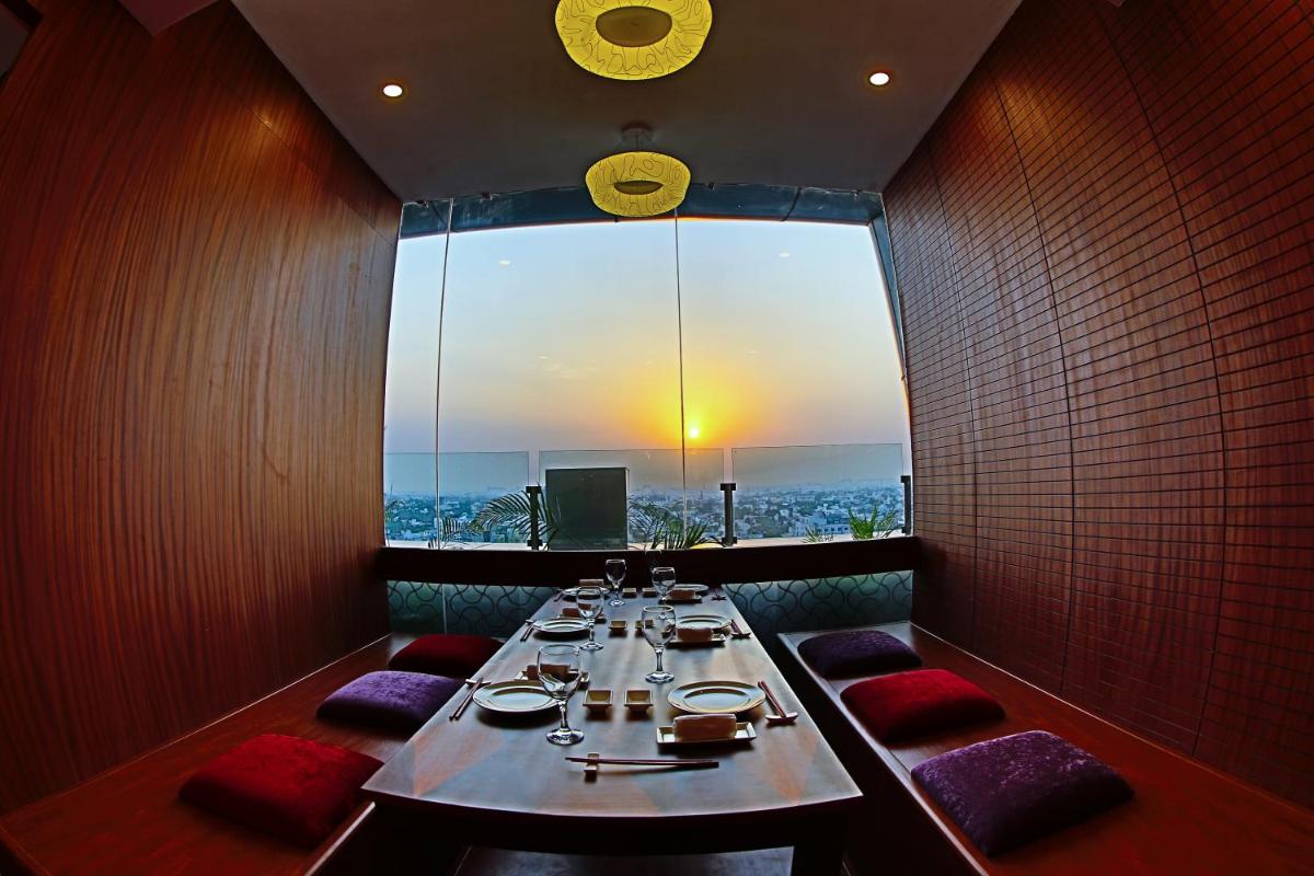 a dining room with a long table and a large window at The Accord Metropolitan in Chennai