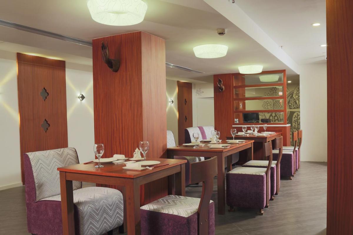 a restaurant with a row of tables and chairs at The Accord Metropolitan in Chennai