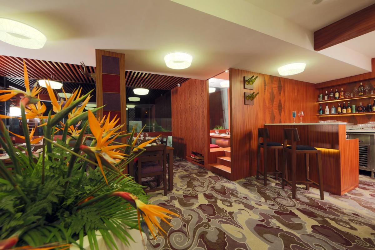 a restaurant with a bar and flowers in a room at The Accord Metropolitan in Chennai