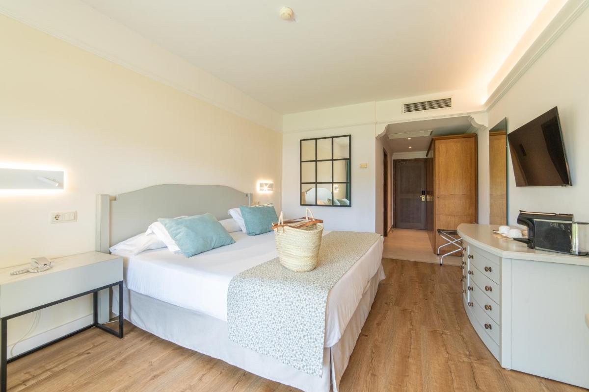 una habitación de hotel con una cama y un televisor en CM Mallorca Palace - Only Adults, en Sa Coma