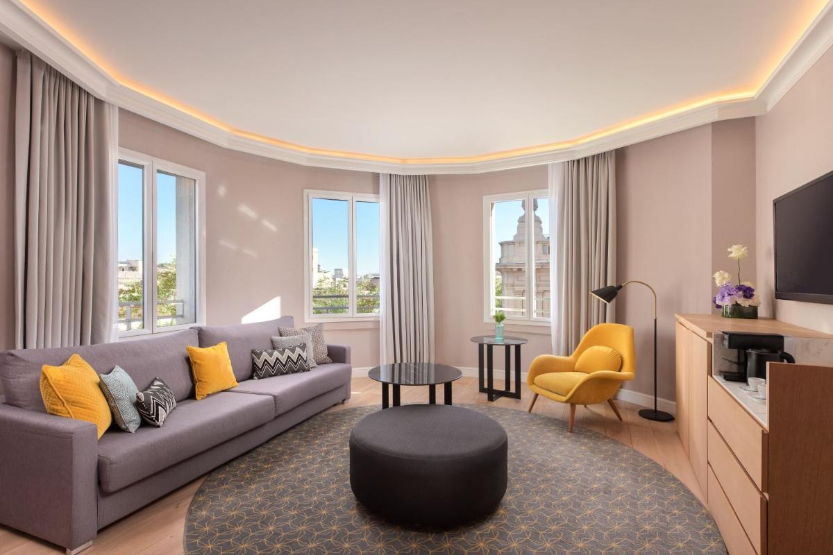 Una sala de estar con un sofá y un televisor. en Le Meridien Barcelona, en Barcelona
