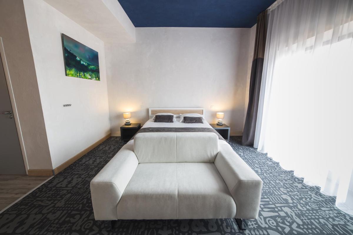 Un ou plusieurs lits dans un hébergement de l'établissement Hôtel Le Dormeur