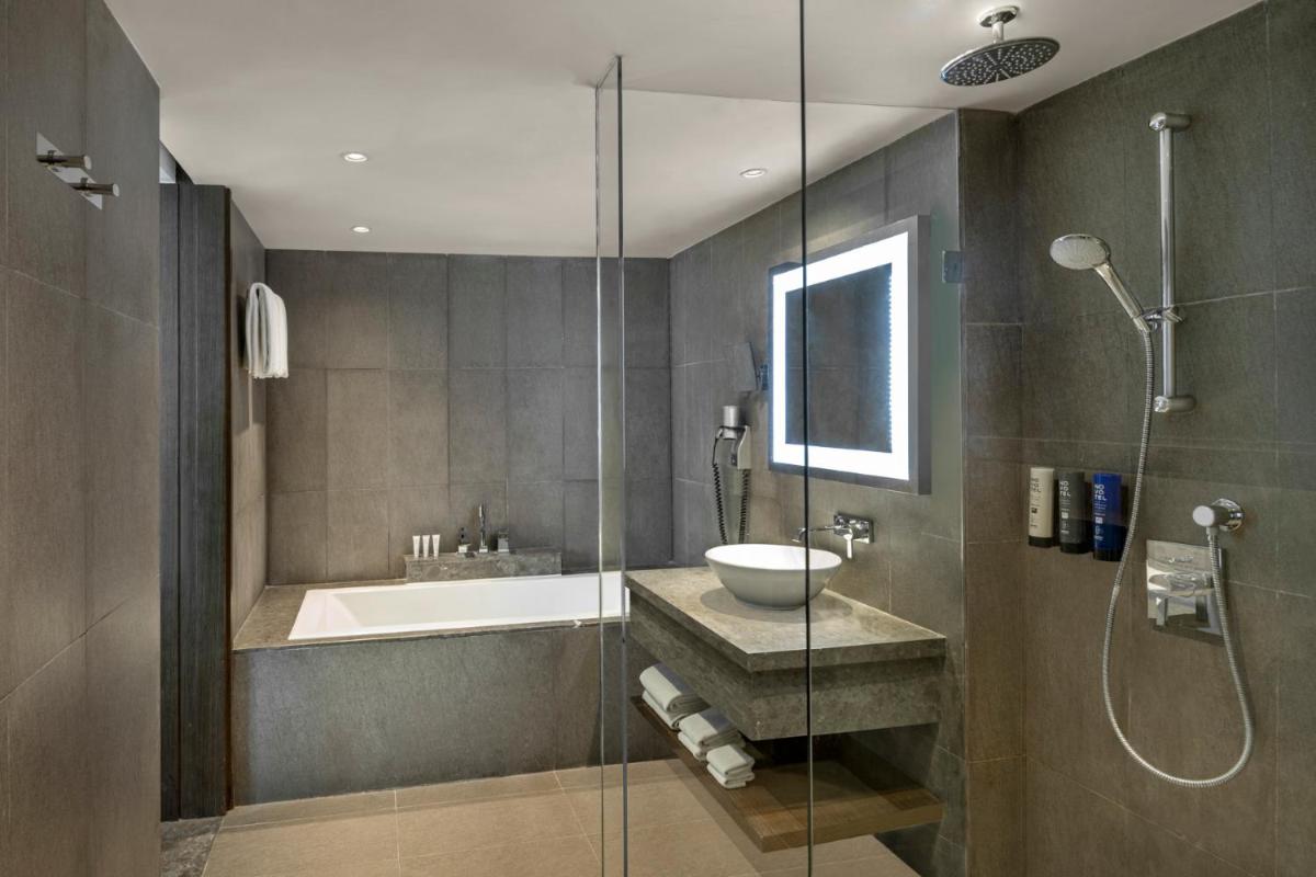 a bathroom with a tub and a sink and a shower at Novotel New Delhi Aerocity in New Delhi