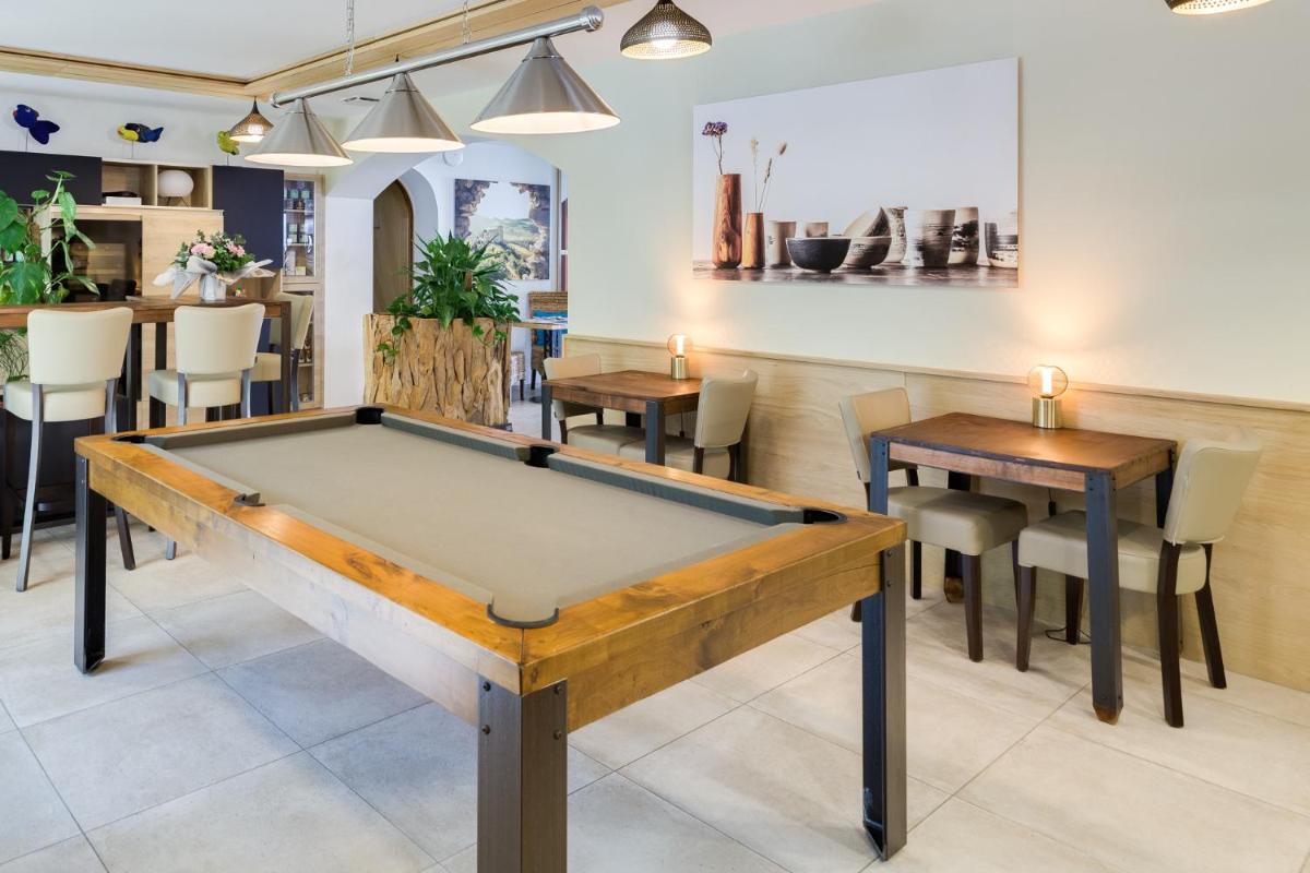 - un billard dans un restaurant avec des tables et des chaises dans l'établissement La Cachette, à Dieulefit