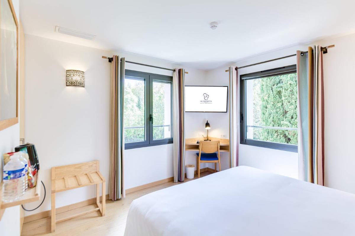 une chambre avec un lit et deux fenêtres dans l'établissement La Cachette, à Dieulefit 21 autres photos