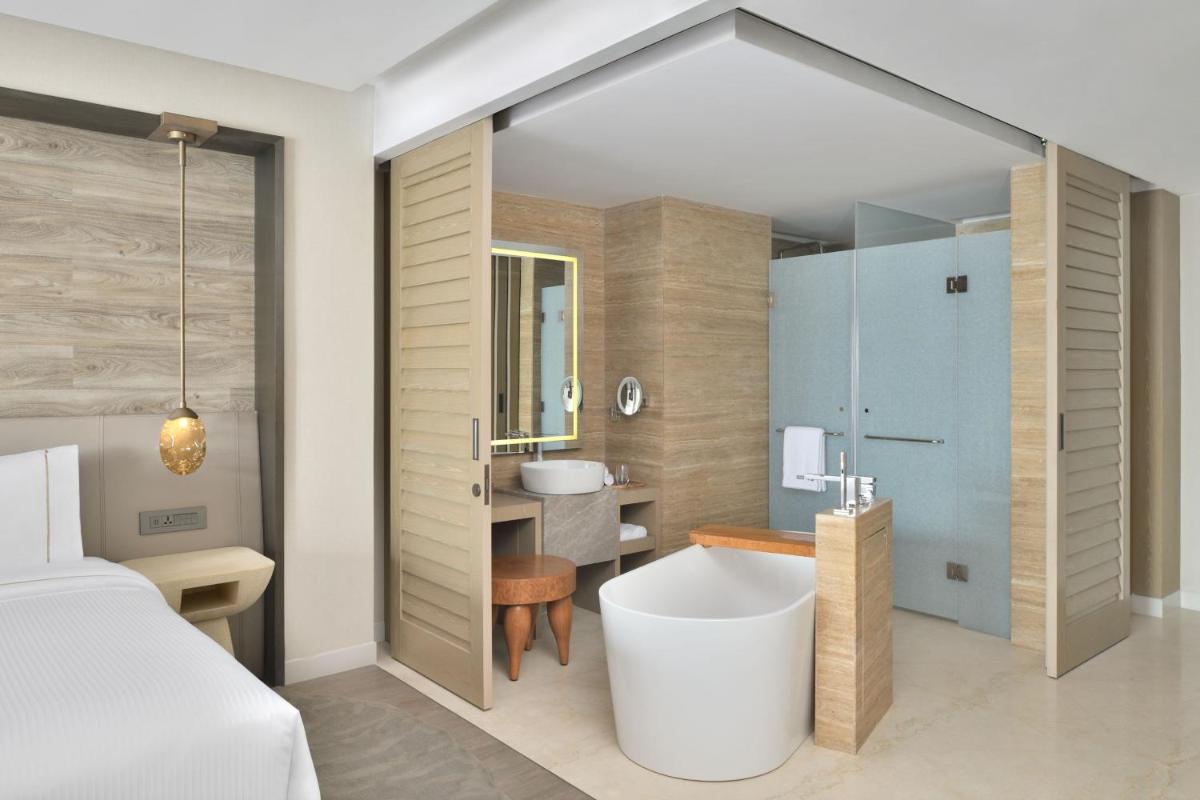 a bathroom with a tub and a sink and a bed at The Westin Resort & Spa Himalayas in Rishīkesh