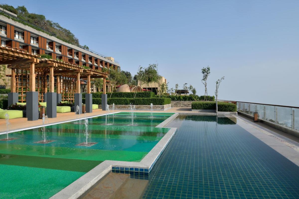 a swimming pool in front of a building at The Westin Resort & Spa Himalayas in Rishīkesh