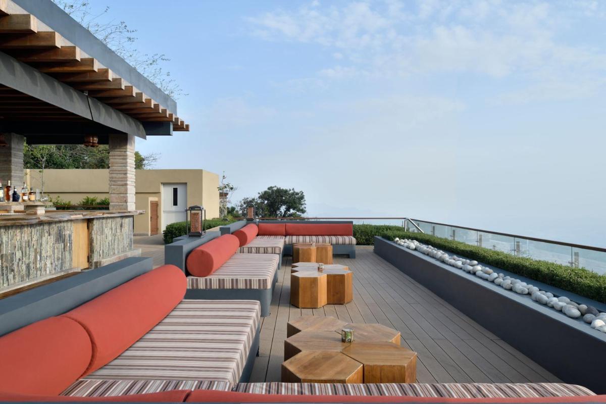 a rooftop patio with benches and tables and the ocean at The Westin Resort & Spa Himalayas in Rishīkesh