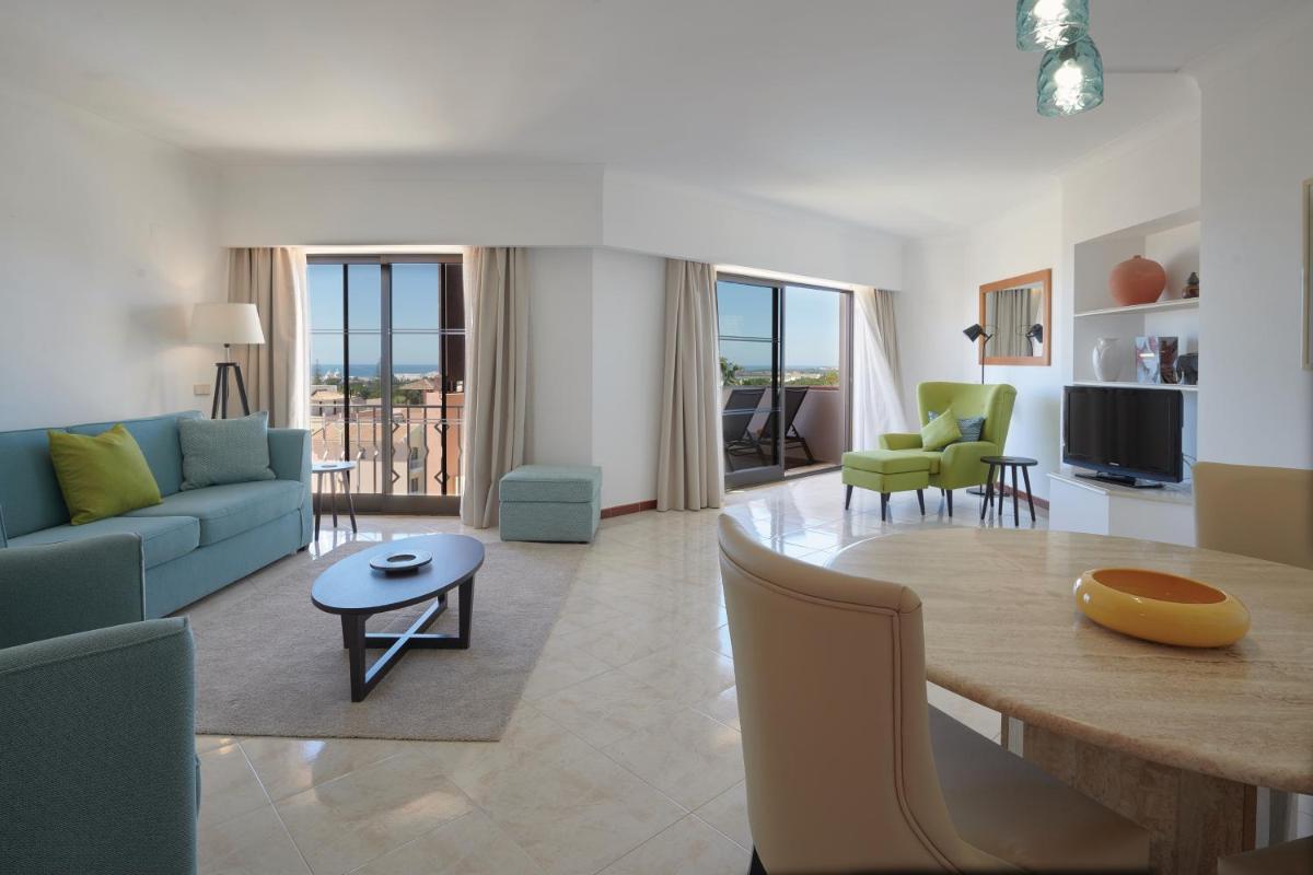 uma sala de estar com um sofá azul e uma mesa em Four Seasons Vilamoura em Vilamoura