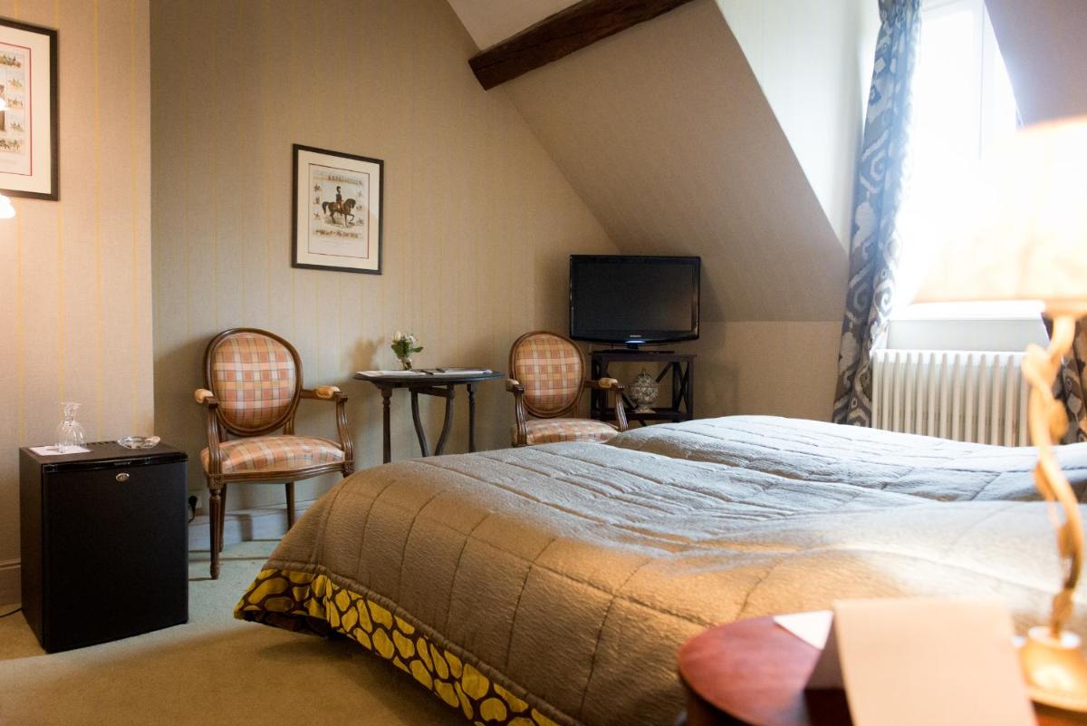 - une chambre avec un lit, deux chaises et une télévision dans l'établissement Chateau De Fere, à Fère-en-Tardenois