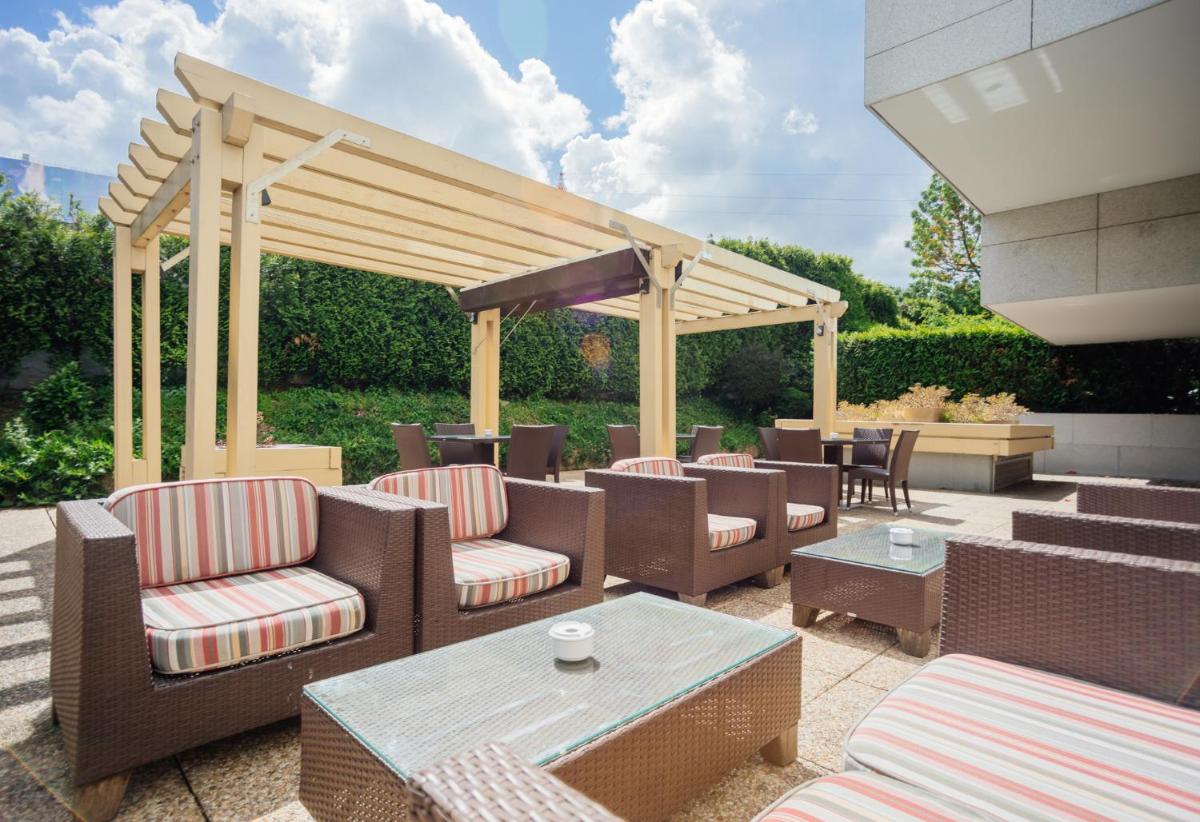 um pátio com cadeiras e um gazebo em Axis Porto Business & Spa Hotel no Porto