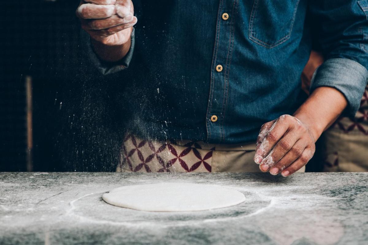 a man is making a pizza on a table at Hyatt Centric Candolim Goa in Calangute a man is making a pizza on a table at Hyatt Centric Candolim Goa in Calangute